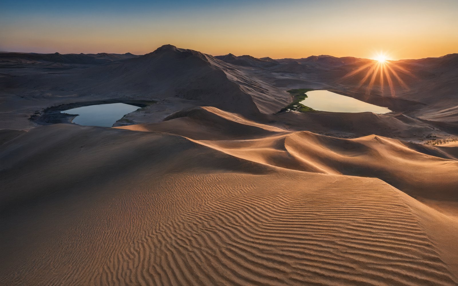 Two small lakes among dunes at sunrise at Shuang Haizi