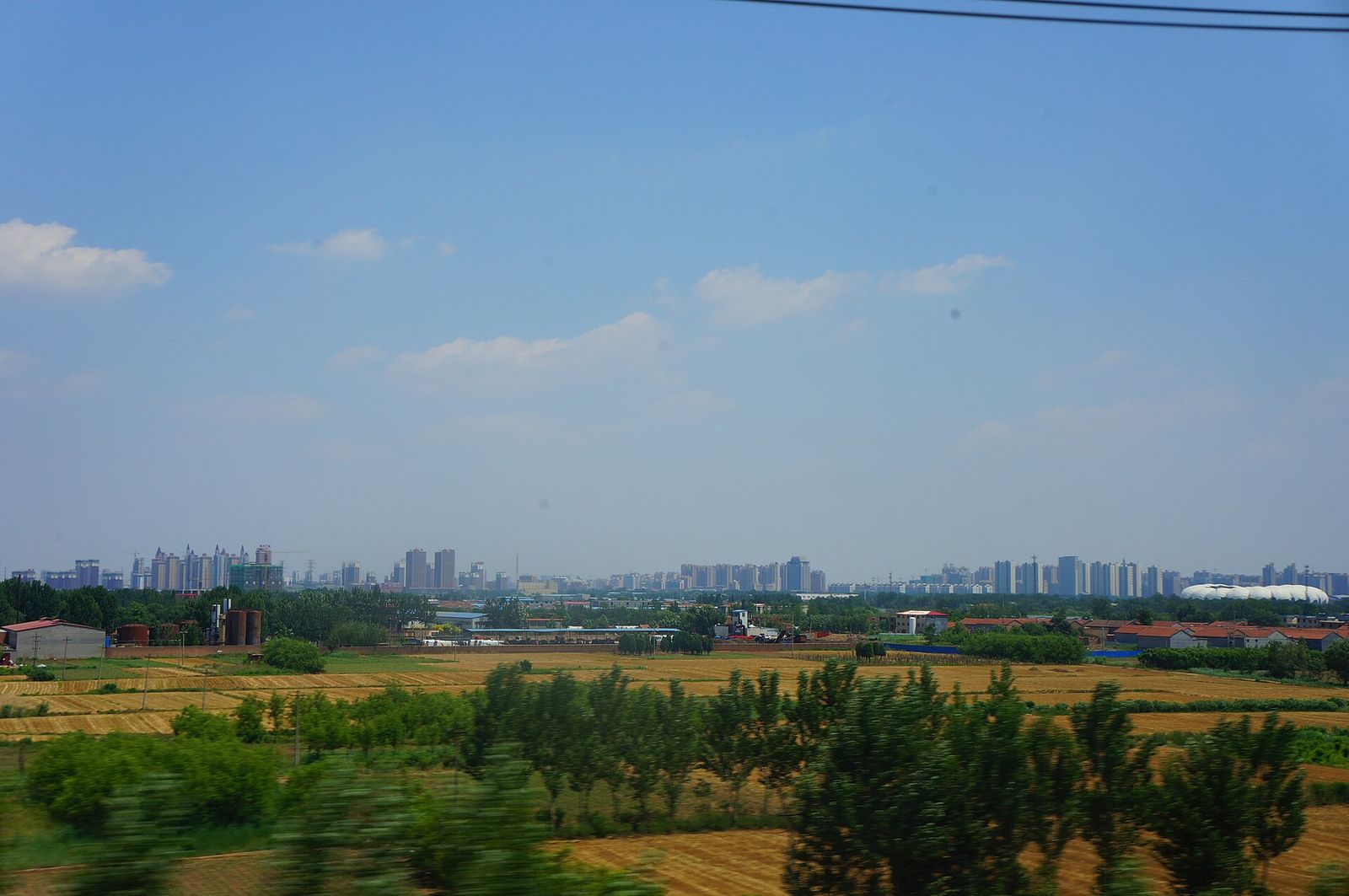 The Cangzhou skyline beyond farmland