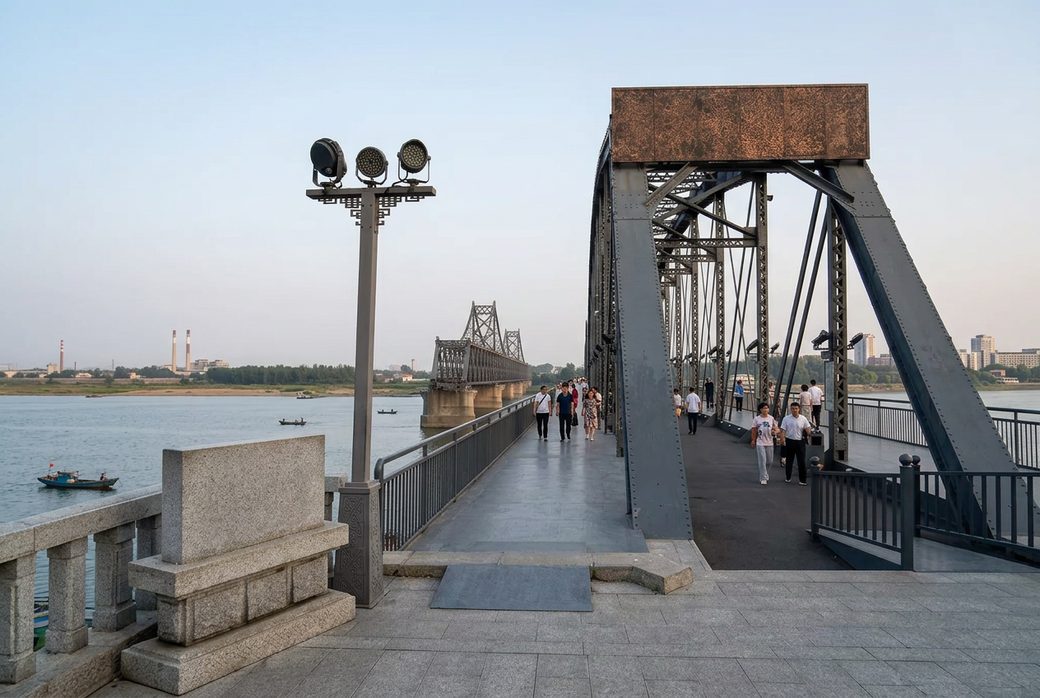 Broken Yalu River Bridge steel spans ending mid river with visitors walking along the preserved section Dandong