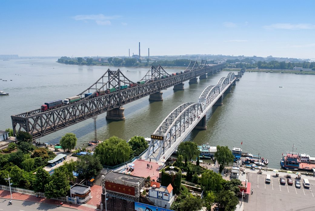 Sino-Korean Friendship Bridge long steel bridge across the Yalu River with trucks crossing Dandong Liaoning
