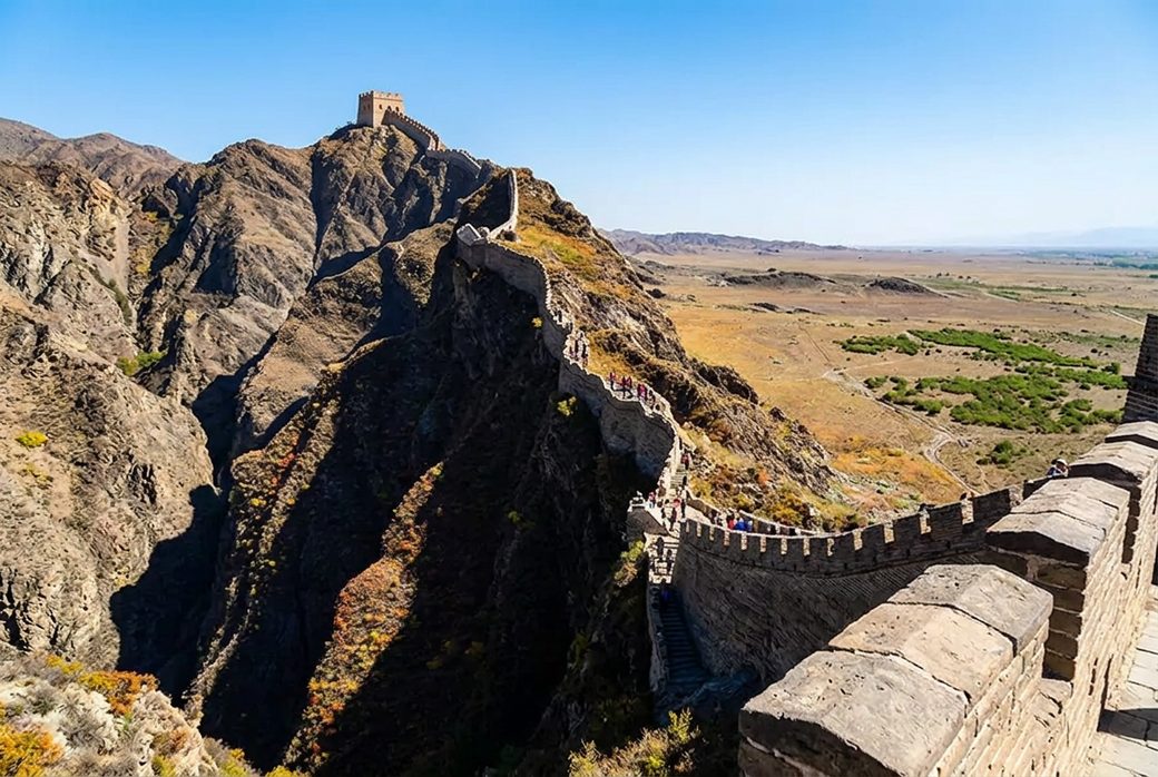 Overhanging Great Wall steep ridge section of the Ming wall climbing a hillside under blue sky Jiayuguan