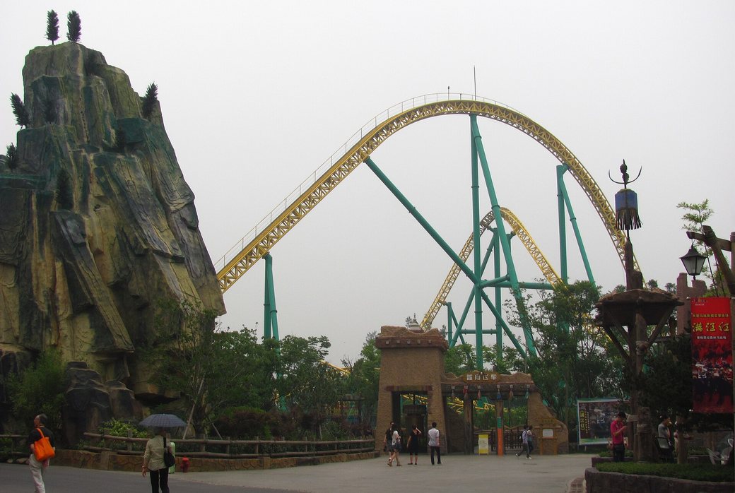 Roller coaster beside a themed rock tower at Happy Valley Shanghai