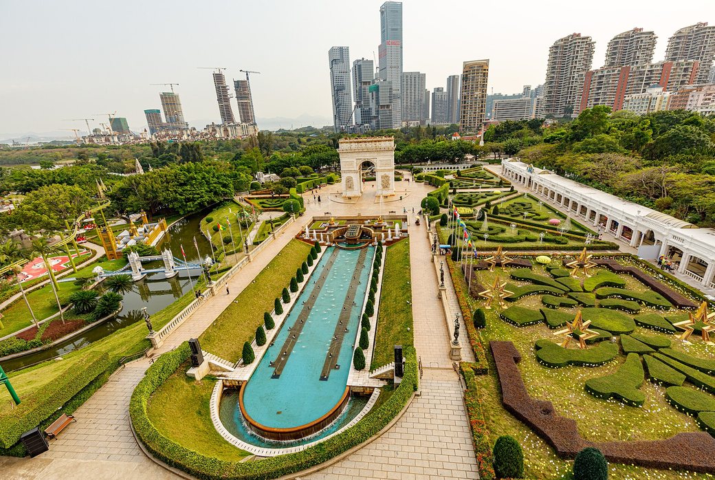 Formal gardens and Arc de Triomphe replica at Window of the World, with the Shenzhen skyline behind