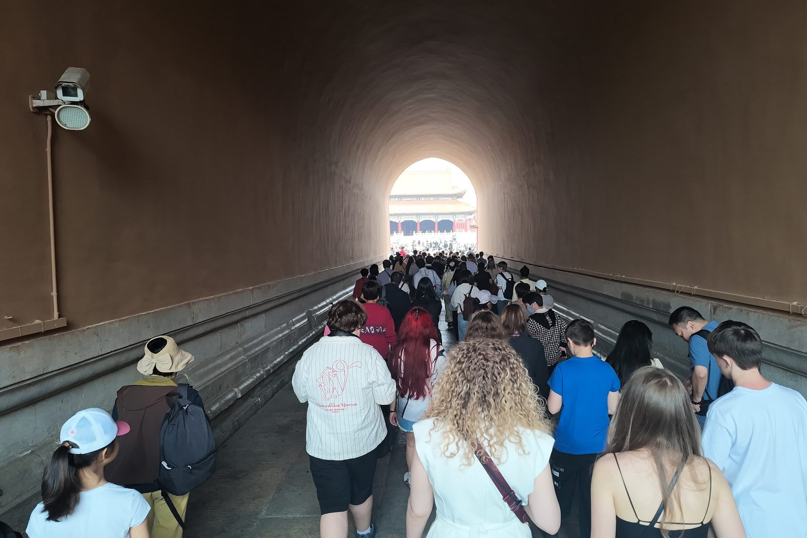 Visitors walking through a vaulted gate passage of the Forbidden City in Beijing