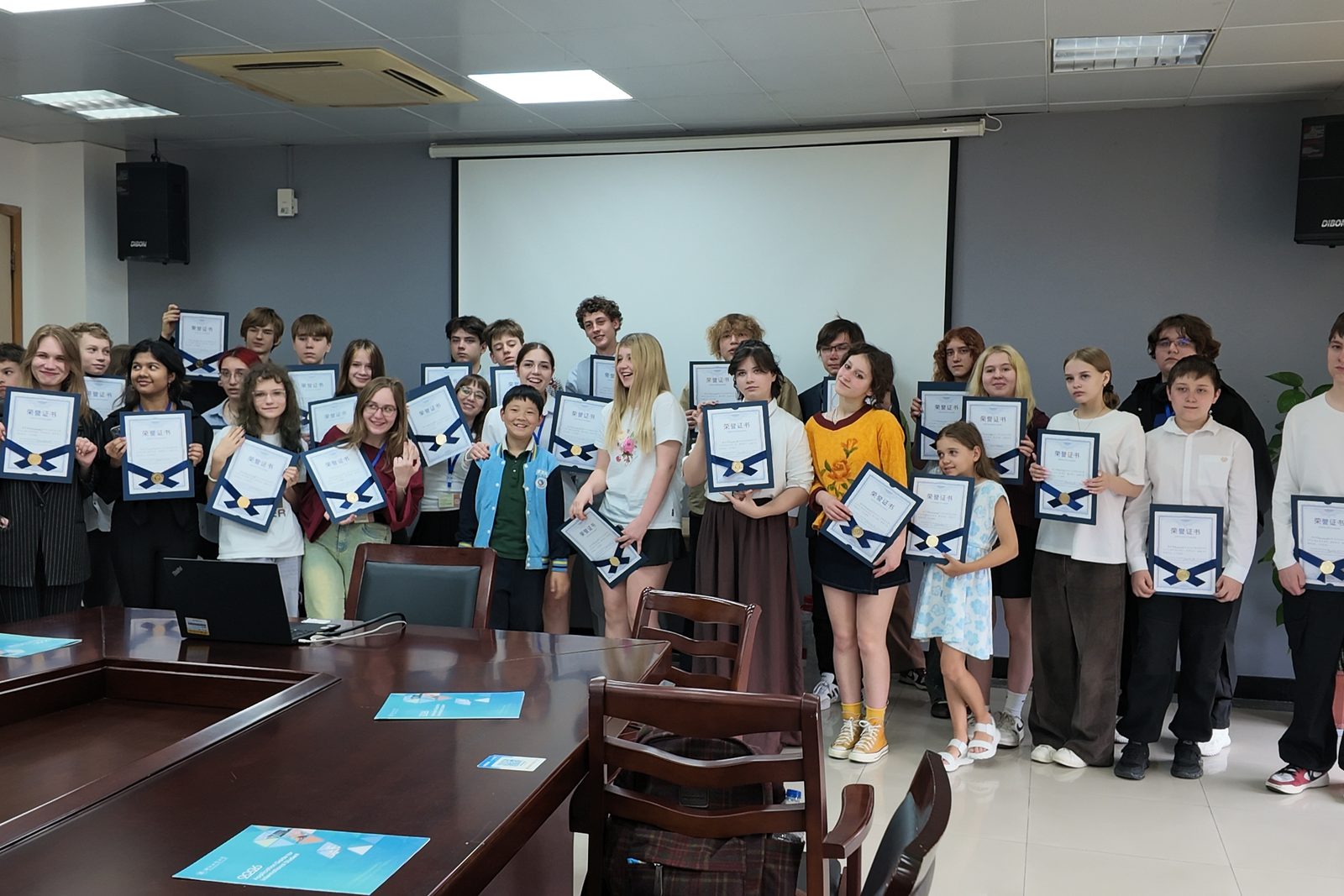 The student group holding certificates after a presentation session at a university in Hangzhou